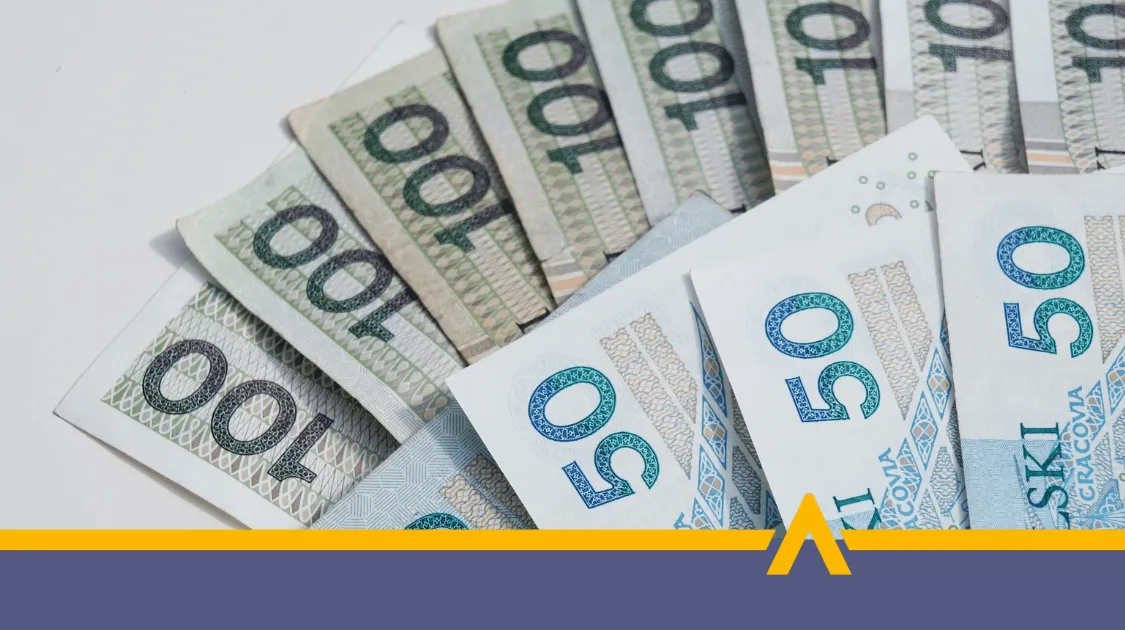 Stos banknotów 50 i 100 zł ułożonych wachlarzowo na jasnym tle,